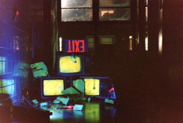 untitled installation (dayglo)  abandoned television sets, spray paint, cracked electronics, trash, black light, tiled hallway  1985 destroyed